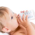 a baby drinking milk from a bottle