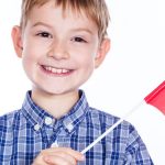 a little boy with polish flag on the white background e1618208009382