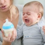 baby crying with bottle