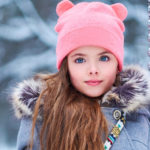 charming little girl on swing in snowy winter e1617949523975 1