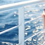 girl enjoying ferry ride staring at the deep blue sea e1621319608806