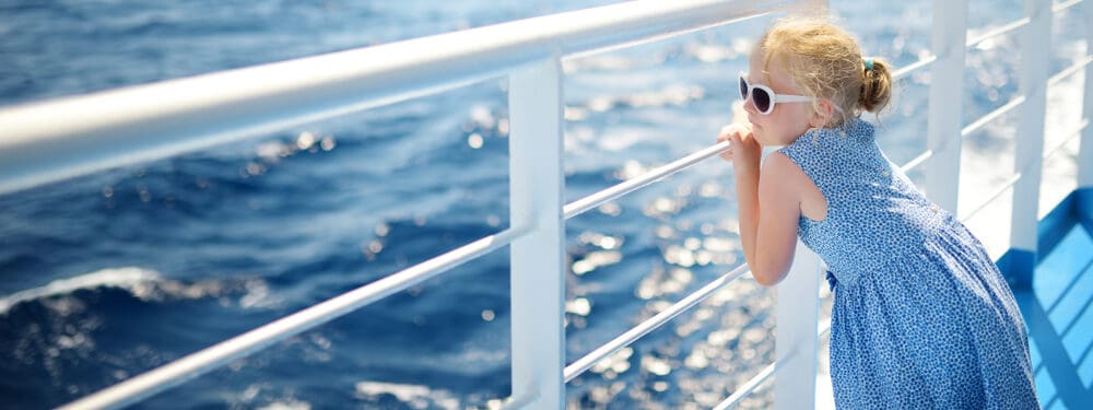 girl enjoying ferry ride staring at the deep blue sea e1621319608806