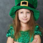 girl in green emerald costume and leprechaun top hat with golden buckle e1618928082373