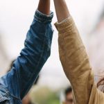 group of activists with holding hands protesting in the city e1620046480250