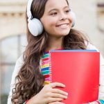 happy child listening to english audio course e1619245448350