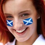 happy female with scottish flags on her cheeks e1619177639518