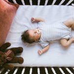 infant laying in crib