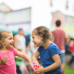 sisters sharing popcorn at fair