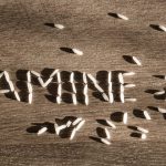 word famine made of few white rice grains on wooden table e1618121759518