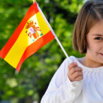 young girl with spanish flag e1618207826147